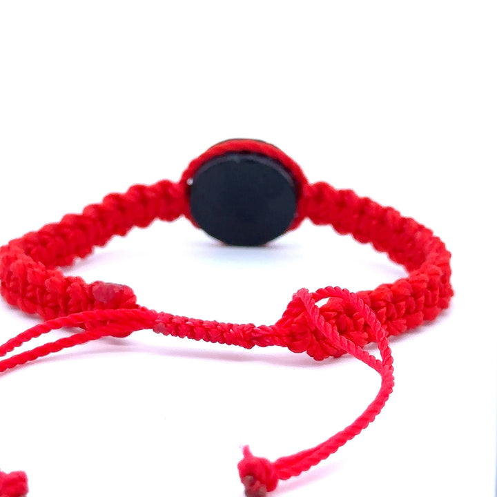 Handmade red Witches Knot Bracelet with wood charm symbolizing faith, unity, and divine protection.